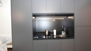 A compact kitchenette with a coffee maker, kettle, and sink. - 407 O "Your Temporary Home in Belgrano". (Ciudad Autónoma de Buenos Aires)