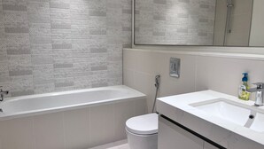 A modern bathroom with a freestanding bathtub, a toilet, a sink, and a shower.