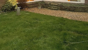 A house with a large glass extension, a brick exterior, and a stone retaining wall. - Charming Home in Huddersfield w/ Parking Petsok (Huddersfield)