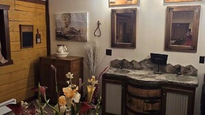 Un baño rústico con detalles de madera, un lavamanos con encimera de piedra e iluminación empotrada.