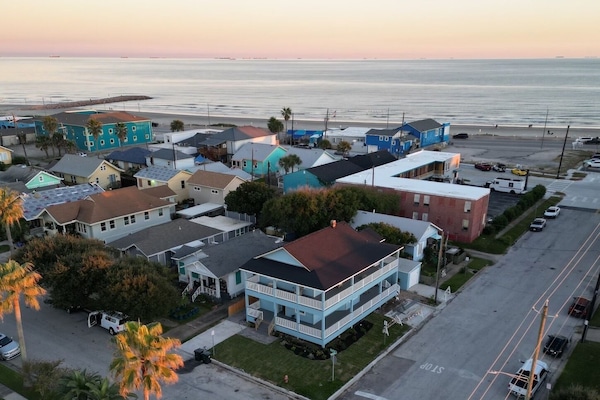 The Lookout at R½ on the Galveston Seawall — the beach is a 2-minute walk from your private top-floor wraparound deck. Golden hour over the Gulf.