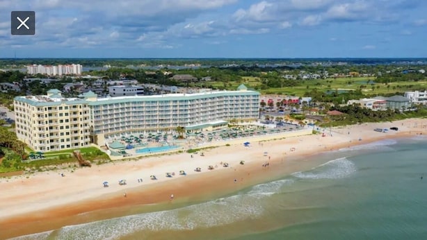 Ein großes Resort mit mehreren Gebäuden, einem Strand und einem Poolbereich.