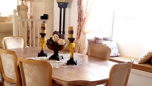 Uma mesa de jantar com quatro cadeiras, uma tigela decorativa e castiçais.