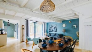 Un comedor con una mesa redonda, cuencos azules y sillas negras.