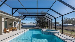Piscina con hidromasaje, terraza techada con mobiliario y una zona cubierta por mosquiteras.
