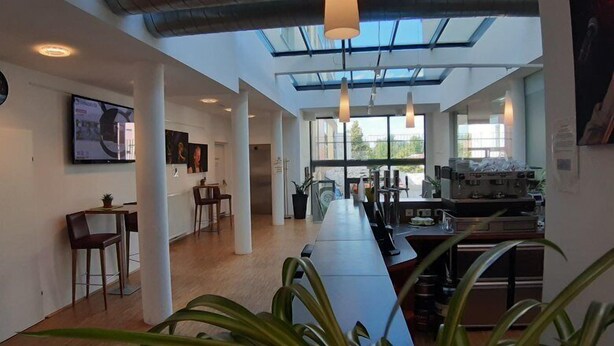 A modern kitchen with a long countertop, large windows, and a skylight. - Stadthotel Waidhofen an der Thaya (Waidhofen an der Thaya)