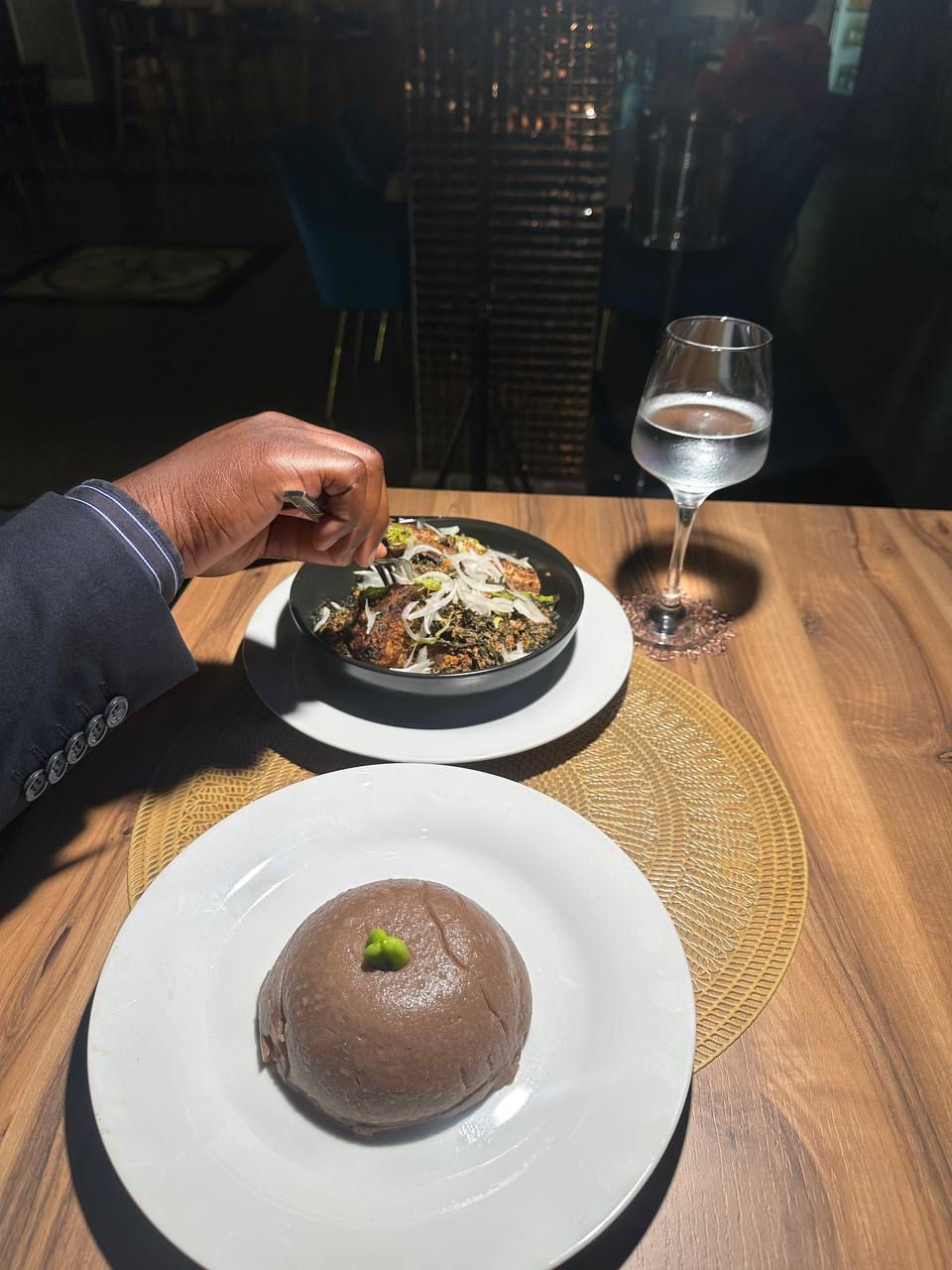 A dining table with a plate of food and a glass of water.