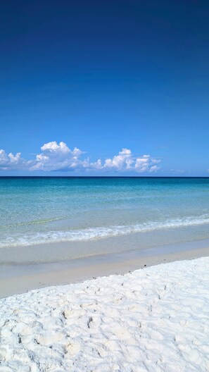 Una platja amb aigua cristal·lina blava i sorra blanca.