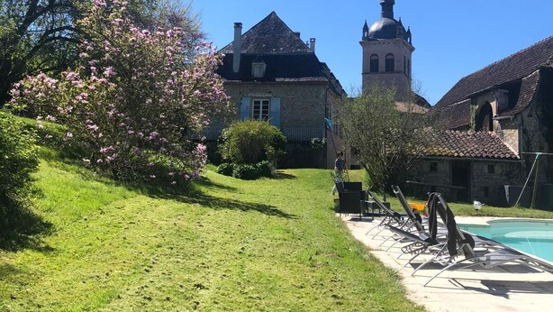 Ein Innenhof mit Schwimmbad, Steinbauten und einem Kirchturm.