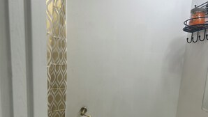 A small, compact bathroom with a toilet, sink, and a toilet paper holder.
