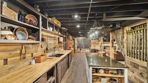 Eine Küche mit Holzböden und -schränken, einer Arbeitsplatte aus Granit und verschiedenen Küchengeräten.