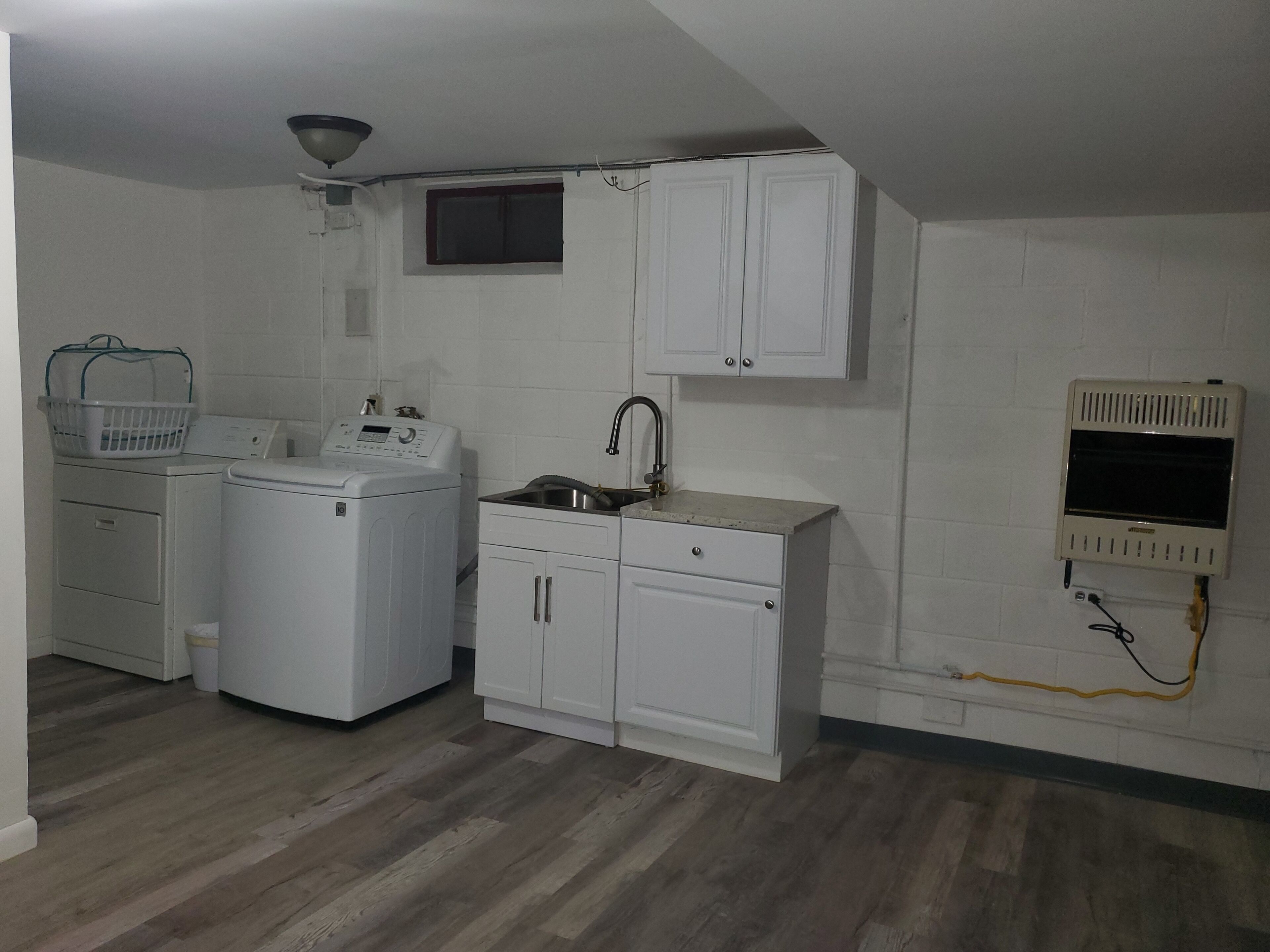 A compact kitchen with a washing machine, dryer, and a small sink.