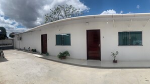 Un edificio con facciata curva, diverse finestre e porte. Lungo l'esterno sono presenti piante in vaso.