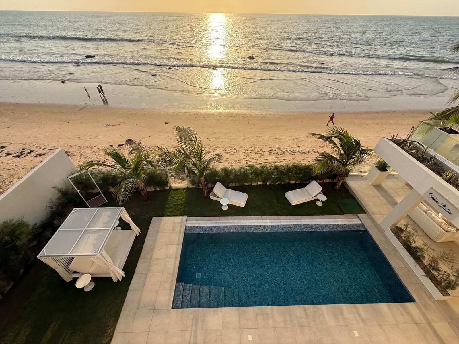 Ein Poolbereich mit Blick auf Strand und Meer.
