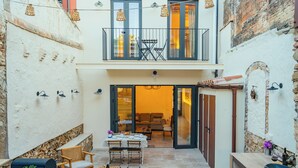 Un patio con comedor, una parrilla y un espacio de estar con sofá y sillas.