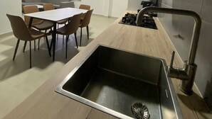 Eine moderne Küche mit Kochinsel, Spüle und Essbereich mit Stühlen.