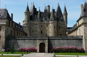 A historic stone castle with multiple towers and a central entrance. - Beautifully  light and spacious 4 bedroomed villa with inground pool (Jumilhac le grand)