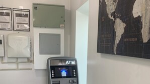 An ATM machine in a hallway with a world map on the wall. - Westview Motel (North Bergen)