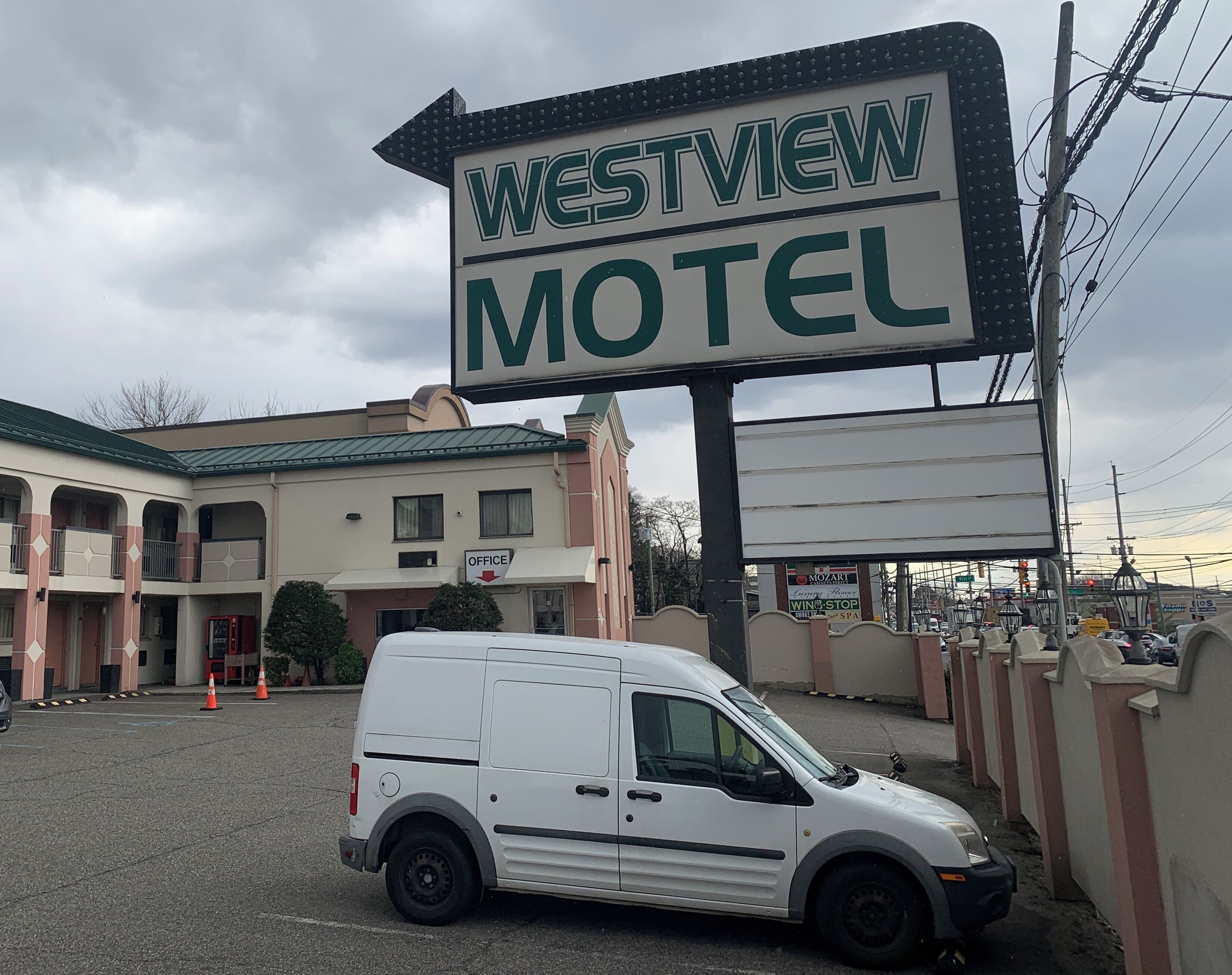 Une enseigne de motel indiquant « Westview Motel », avec un fourgon blanc garé devant.