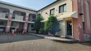 A building with a beige facade, multiple balconies, and a sign indicating an office. - Westview Motel (North Bergen)