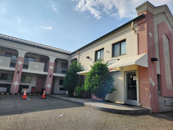 Un edificio con fachada color beige, varios balcones y un cartel que indica que es una oficina.