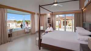 Ein geräumiges Hotelzimmer mit einem großen Bett, einem Balkon mit Blick auf das Resort und einer separaten Sitzecke mit Blick auf den Pool.