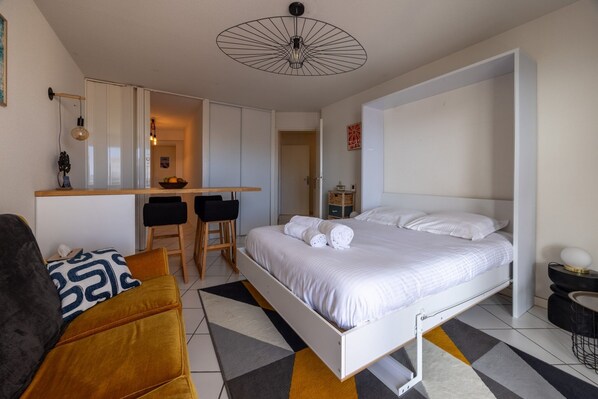 Un dormitorio moderno con una cama, un escritorio y un sofá.