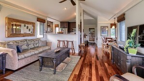 A spacious living room with a sofa, coffee table, and wooden flooring. - Hanalei Bay Villa 8 (Princeville)