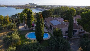 A large house with a swimming pool, surrounded by trees and a view of a lake and bridge. - Villa Bella Vista - Paceco (Paceco)
