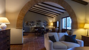 A cozy living room with a stone archway, a fireplace, and a dining area with bookshelves. - Villa Bella Vista - Paceco (Paceco)