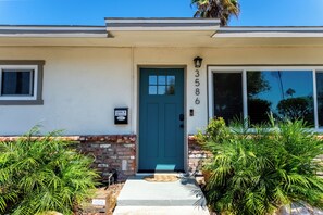 A residential building with a blue door, numbered 3586, and a mailbox.