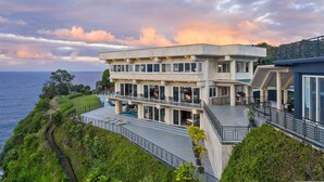 Un bâtiment moderne à deux étages, doté d’une piscine et offrant une vue sur un plan d’eau.