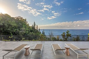 A terrace with sun loungers and a view of the sea.