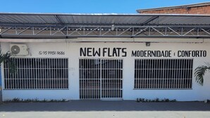 Un immeuble portant l’inscription « NOUVEAUX APPARTEMENTS, MODERNITÉ ET CONFORT ».