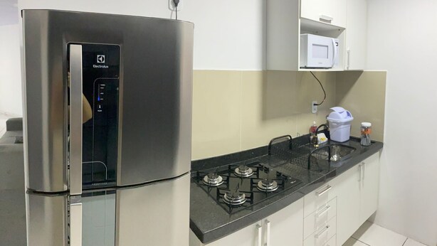 Une cuisine moderne équipée d’un réfrigérateur en acier inoxydable, d’un four à micro-ondes et d’une cuisinière à gaz.