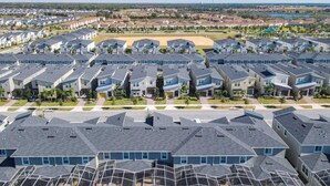 A residential area with modern houses, a central open space, and a swimming pool area. - Last Minute Disney Getaway! Townhouse with Private Pool. Book Now! #128831 (Orlando)
