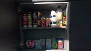A kitchen with a built-in shelf above the sink containing various condiments and spices. - Central Trafford Apartment Free Parking (Manchester)