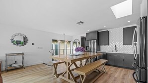 Una cocina moderna con una mesa de comedor de madera, un banco y una planta en maceta.
