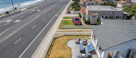 A residential area with a road, a beach, and houses with a patio.