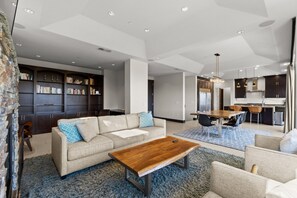 A modern living room with a sofa, coffee table, and bookshelf. - Dana Point Luxe Str14-007 (Dana Point)