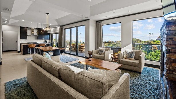 A modern living room with a sofa, coffee table, and dining area. - Dana Point Luxe Str14-007 (Dana Point)