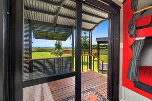 A room with a view of a grassy area and a red fence.