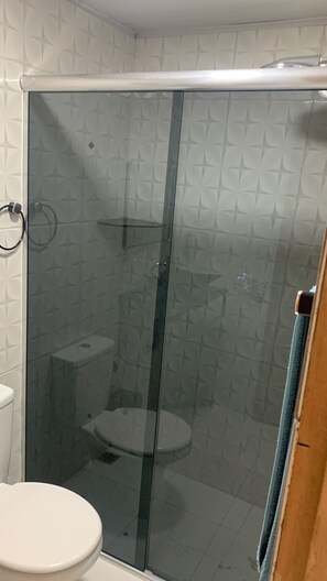Chuveiro, toalhas de banho, sabonete, papel higiênico