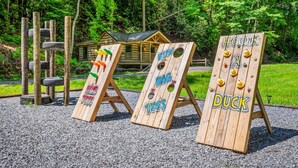 Udendørs træskilte til ringkastspil med teksterne 'RING TOSS', 'BAG TOSS' og 'AND'.