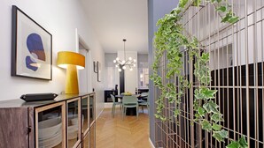 Un intérieur moderne avec un coin repas, une lampe jaune et un mur recouvert de plantes grimpantes.