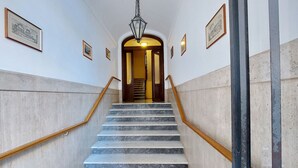 Un escalier en marbre avec des rampes en bois menant à une porte.