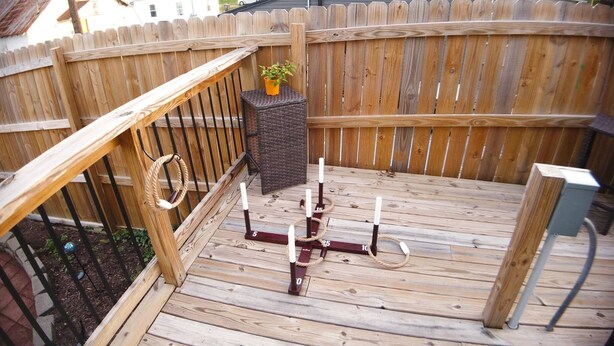 A wooden deck with a rope swing, a small brick planter with a plant, and a metal bench. - Bristol Abode (Bristol)
