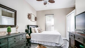 A bedroom with a bed, dresser, television, and ceiling fan. - Bristol Abode (Bristol)