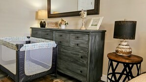 A baby playpen next to a dresser with a mirror above it. - Bristol Abode (Bristol)