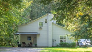 A two-story house with a covered porch, a garage, and a small shed.